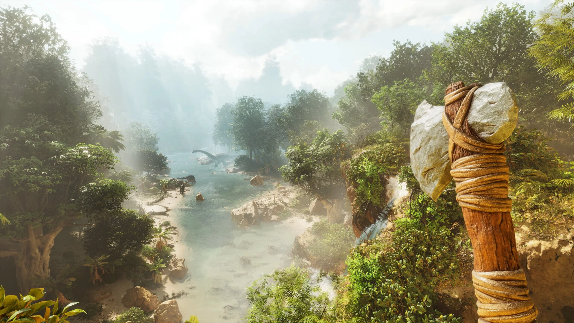 A first-person view in Ark: Survival Ascended, showing a primitive stone axe in the foreground overlooking a lush, misty, prehistoric jungle river with tall trees and distant dinosaurs.