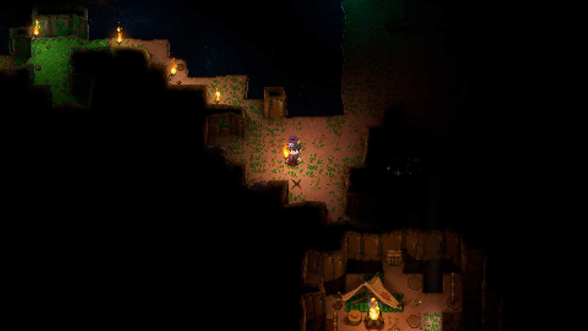 A Core Keeper player stands in a lit underground passage, with a wooden crate visible in the bottom right and an 'X' mark on the ground nearby, indicating hidden loot or resources.