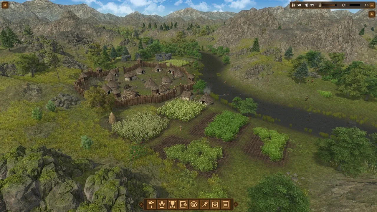Dawn of Man gameplay screenshot showing an early human settlement surrounded by a wooden palisade, with thatched-roof dwellings and cultivated plots, set in a lush, mountainous landscape.