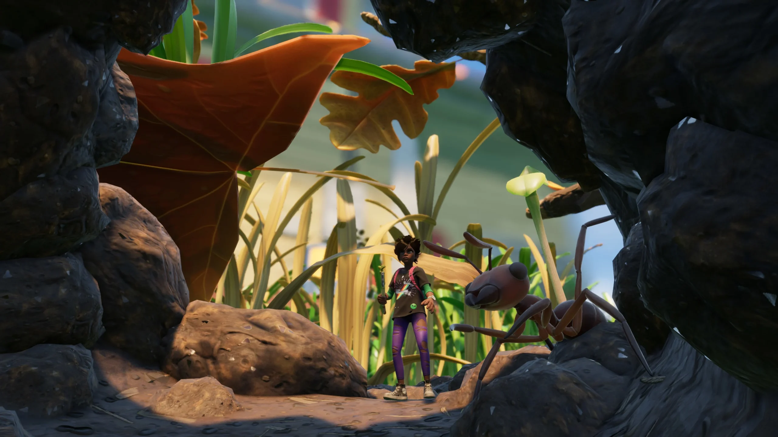 A small, human-sized character stands between large rocks with an ant nearby, seen from a 'bug's eye view' in the game Grounded.