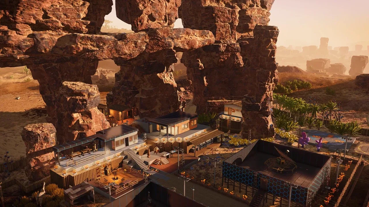 A settlement built into a red rock canyon on an alien planet in Stranded: Alien Dawn, with several futuristic buildings and farmlands.