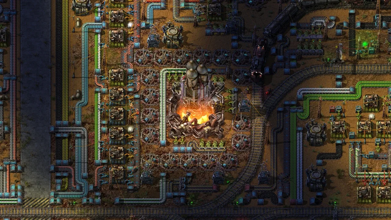 An overhead view of a vast, complex factory in Factorio, filled with an intricate network of conveyor belts carrying various resources, automated assembly machines, pipes, and rail tracks, all indicating a highly efficient and sprawling industrial operation.